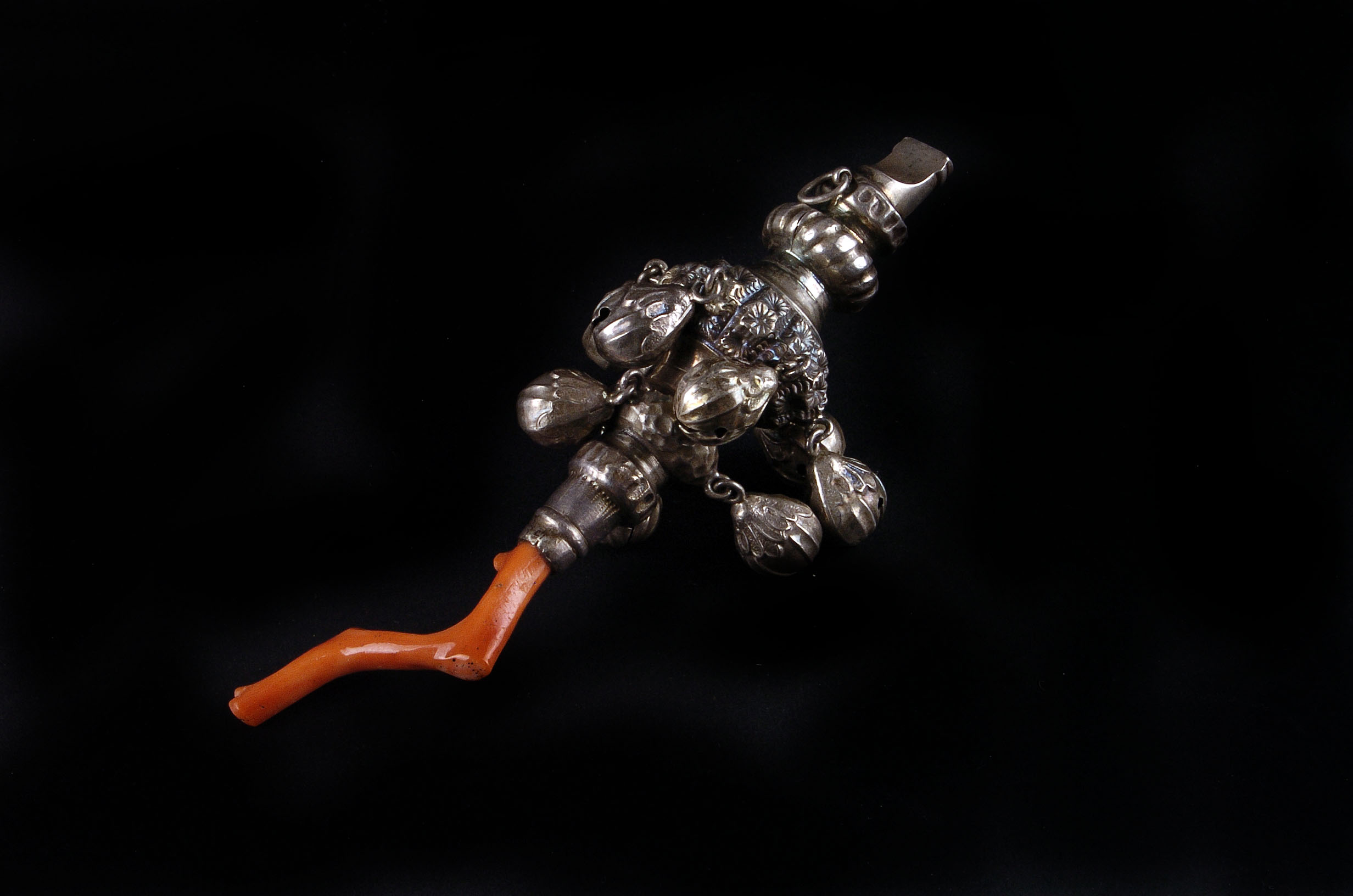 An Edwardian child’s silver rattle, Chester 1911, with coral teether, nine bells and an integrated