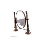 A silver plated dressing table  mirror,  the oval mirror between two tapering column supports,