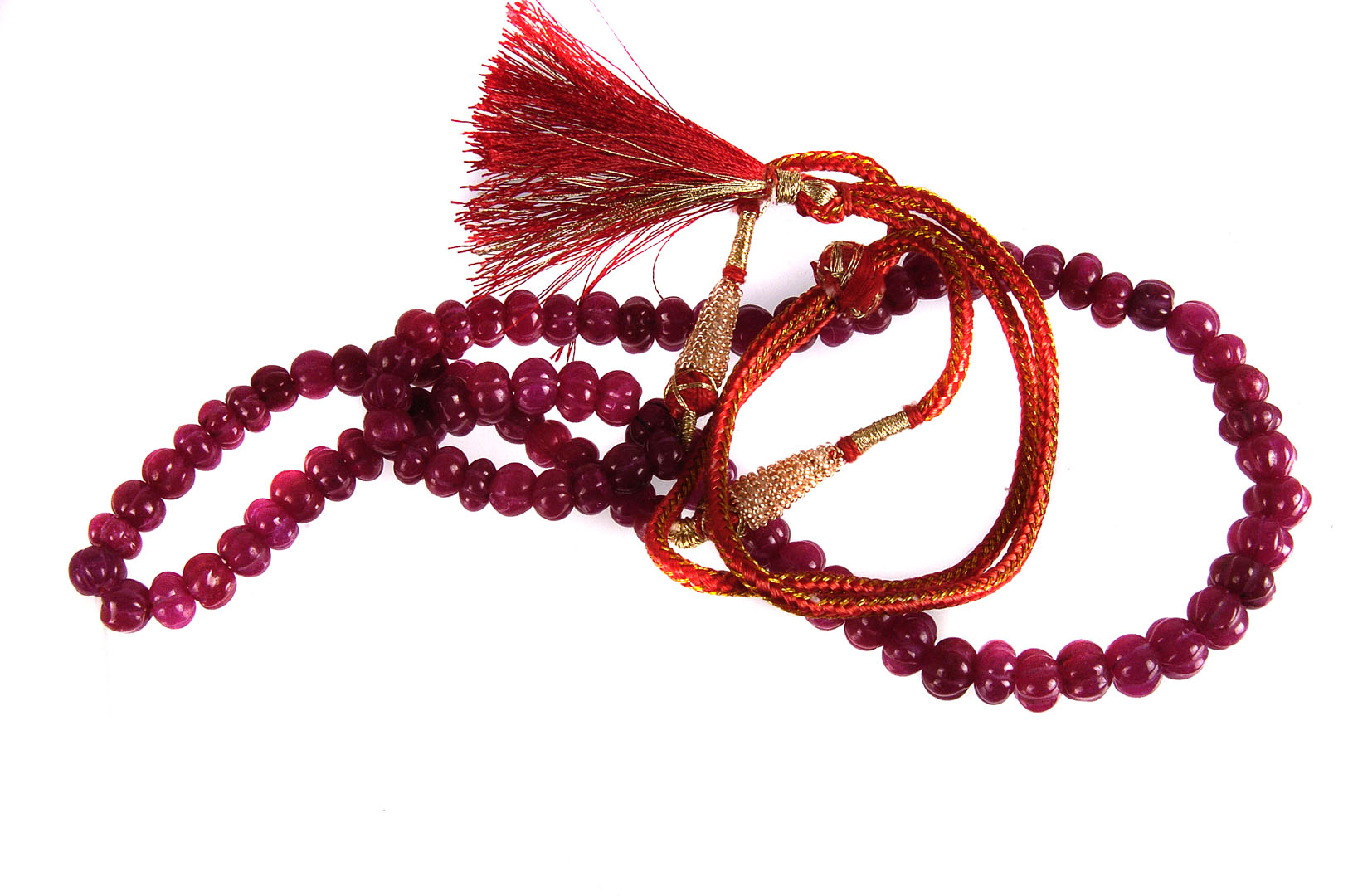 A melon cut ruby necklace,  with two colour silk cord tie