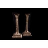 A pair of later Victorian silver Corinthian Column candlesticks,  London 1900, to a stepped