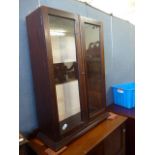 A small Edwardian mahogany elevated bookcase top, with glazed doors enclosing pegged adjustable