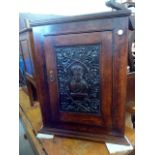 A Victorian oak corner cabinet, with earlier carved panel of a bust of Jesus in an olive wreath