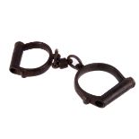 A pair of early 20th century handcuffs, the two iron cuffs join but two links and a swivel centre