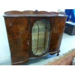 A 1950s walnut bookcase display cabinet, with cloud gallery back over glazed centre flanked by