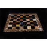 A sample stone chess board,  40cm squared, together with a 19th century travelling chess case,