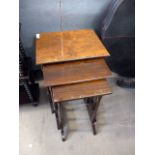 A mid-20th century nest of three walnut tables, the largest with quartermatched veneers, all on