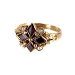 A Georgian style gem set dress ring, having four purple cut stones and four seed pearls in a