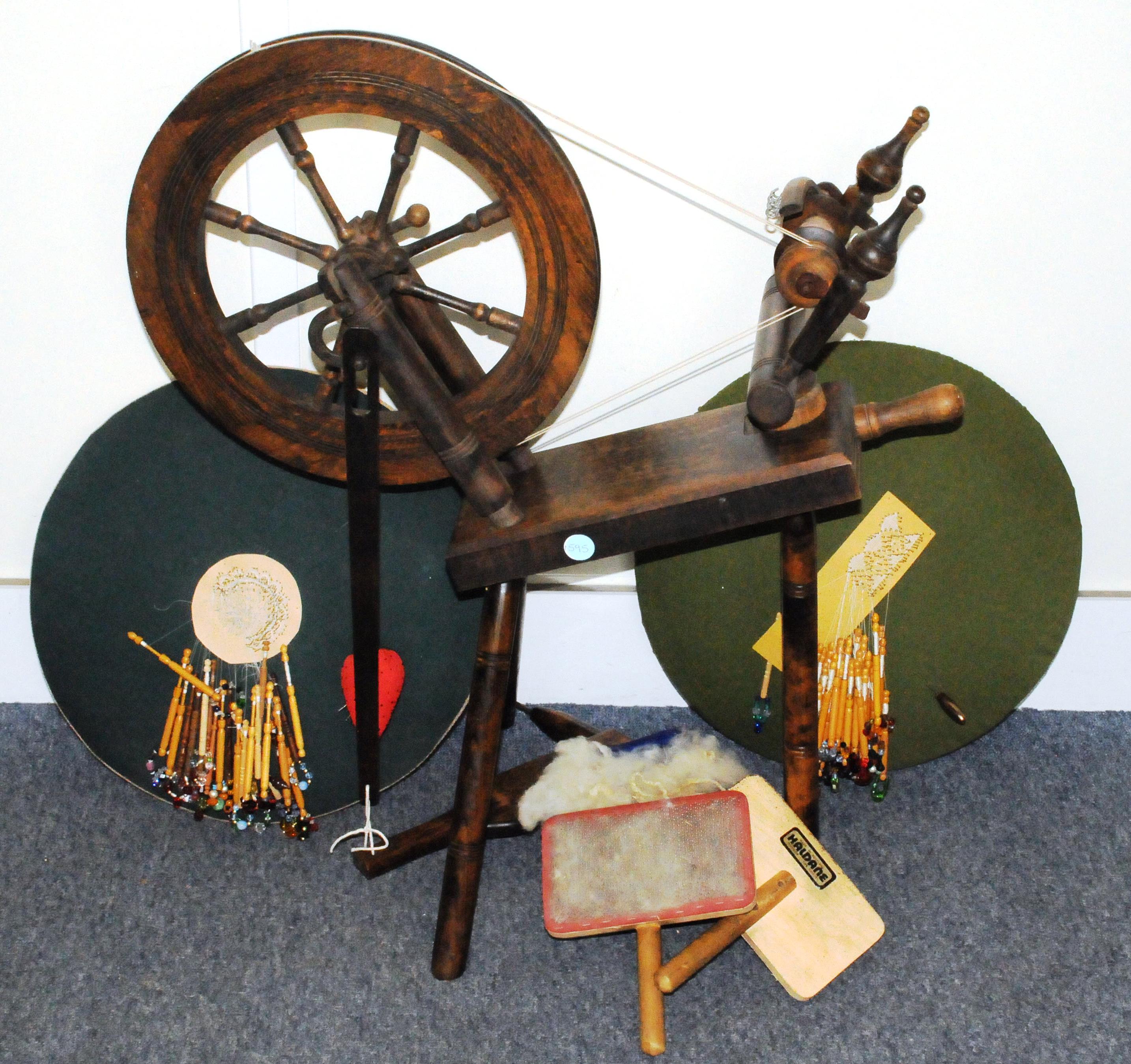 A 1970s wool spinning wheel by Haldane, together with two wool paddles and two lace makers