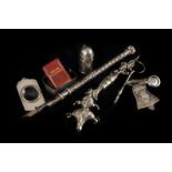 A small group of silver and white metal items, including a silver jester child’s rattle mount, a