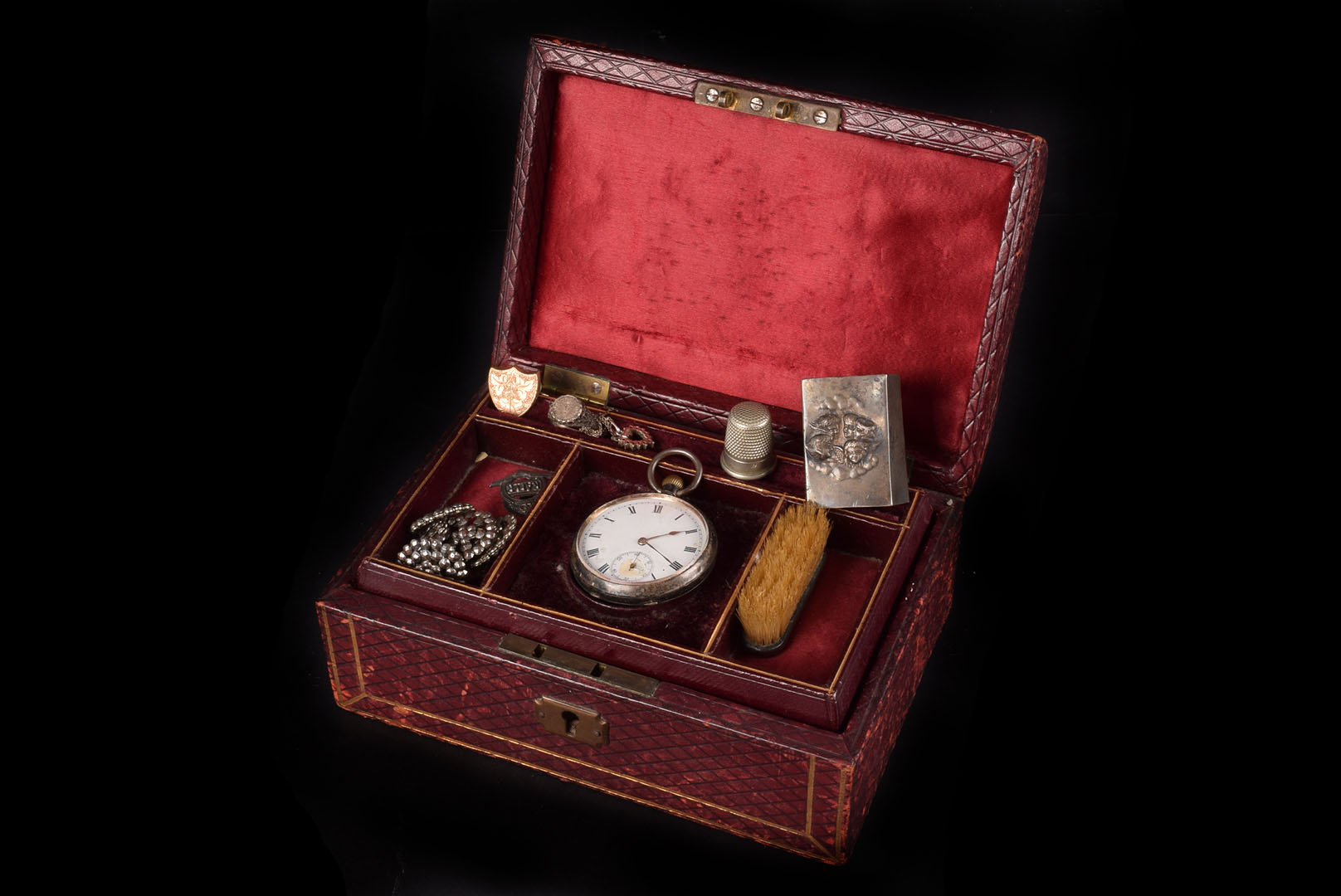 A tooled red leather jewellery box, containing miscellaneous items, including a silver open faced