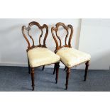 A pair of Victorian rosewood dining chairs, with ornate back splat and upholstered seats (2)