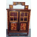 A late 19th or early 20th century Chinese cabinet, red painted with gilt decoration, having two