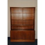 A 1970s Danish teak bookcase cabinet, the upper section with adjustable shelves, the lower with