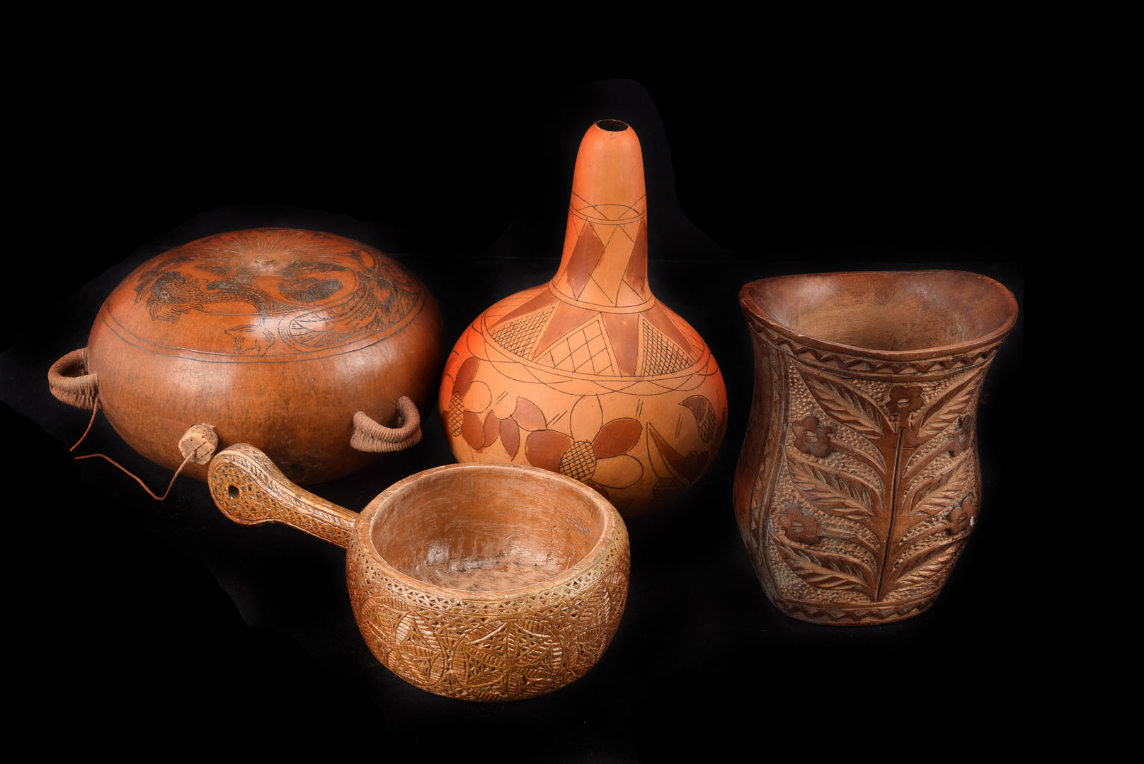 A collection of gourds and carved nuts, including a coquilla nut, an engraved gourd, another