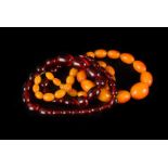 Two vintage amber style necklaces, both with graduating sized beads, one in cherry colour, the other