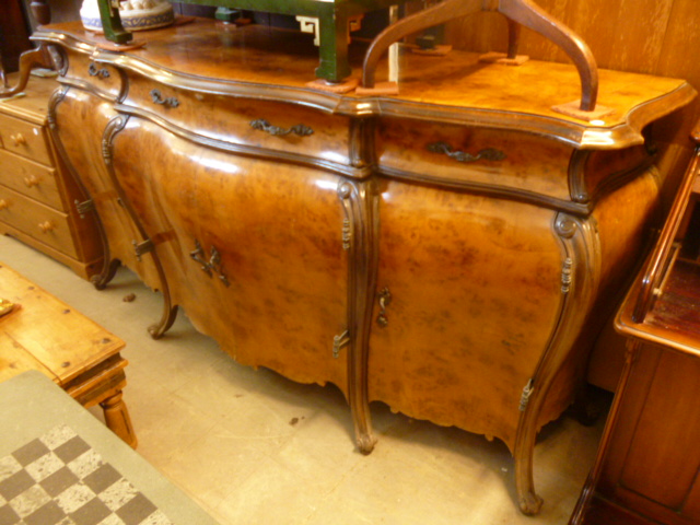 A large 20th century bombe side board, on sweeping legs to scroll feet