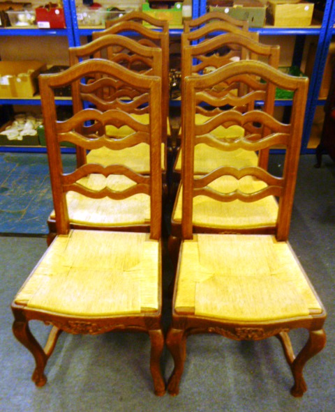 A set of eight oak framed rush seat dining chairs, with carved apron and on cabriole legs, to