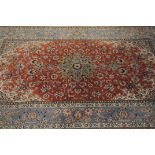 A modern Iranian silk carpet, light blue and coral ground with ornate designs, signed to one end,