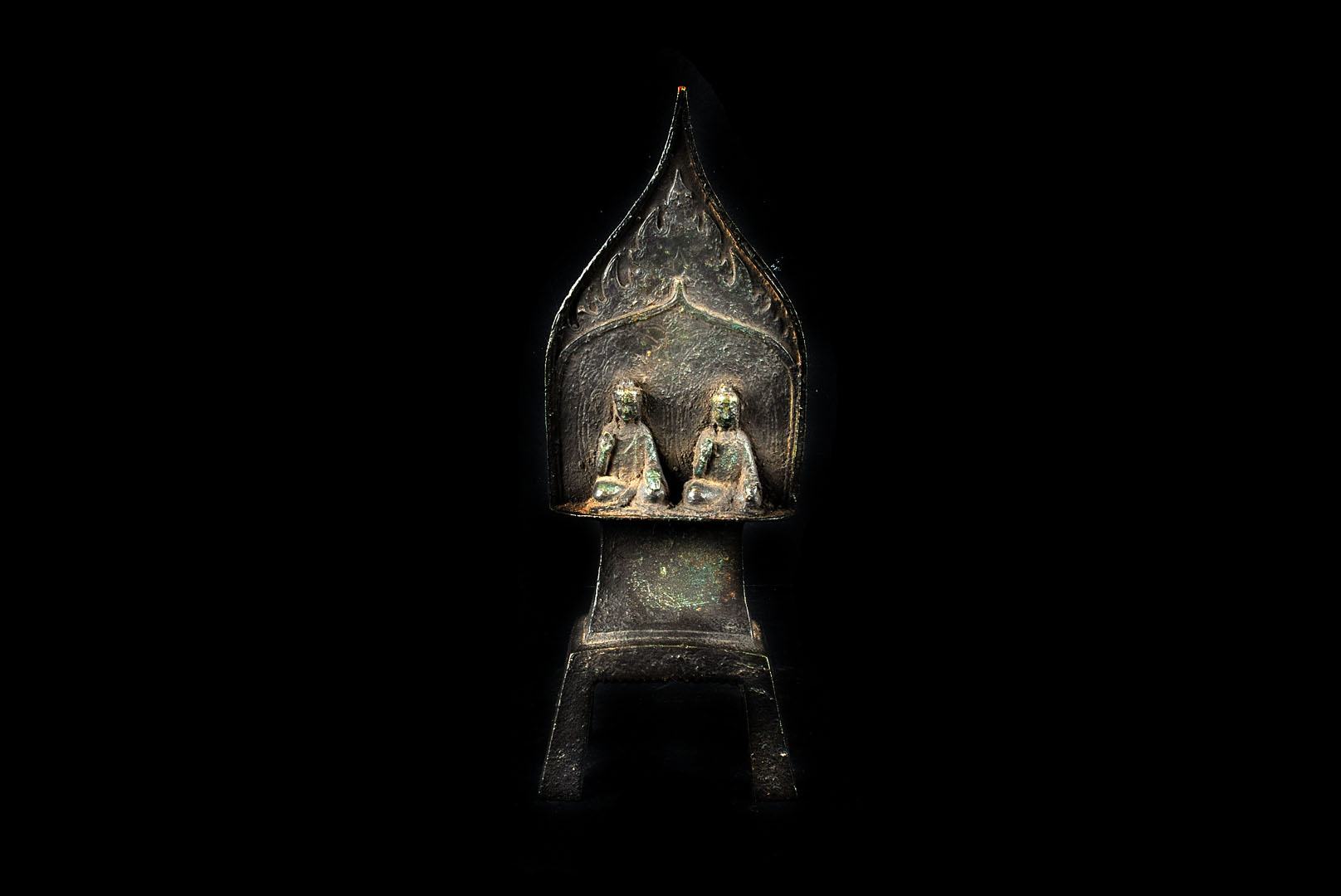 A 19th century Tibetan bronze devotional piece, having two seated figures on engraved flame shaped