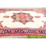 A very large Indian woollen carpet, with red and white ground and bright colour medallion to