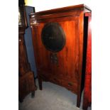 A Chinese Qing dynasty elm moon cabinet, or betrothal cabinet, the double doors with circular plaque