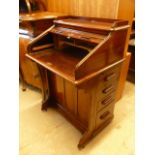 An early 20th century mahogany Lebus roll top desk, the tambour opening to reveal pigeon holes,