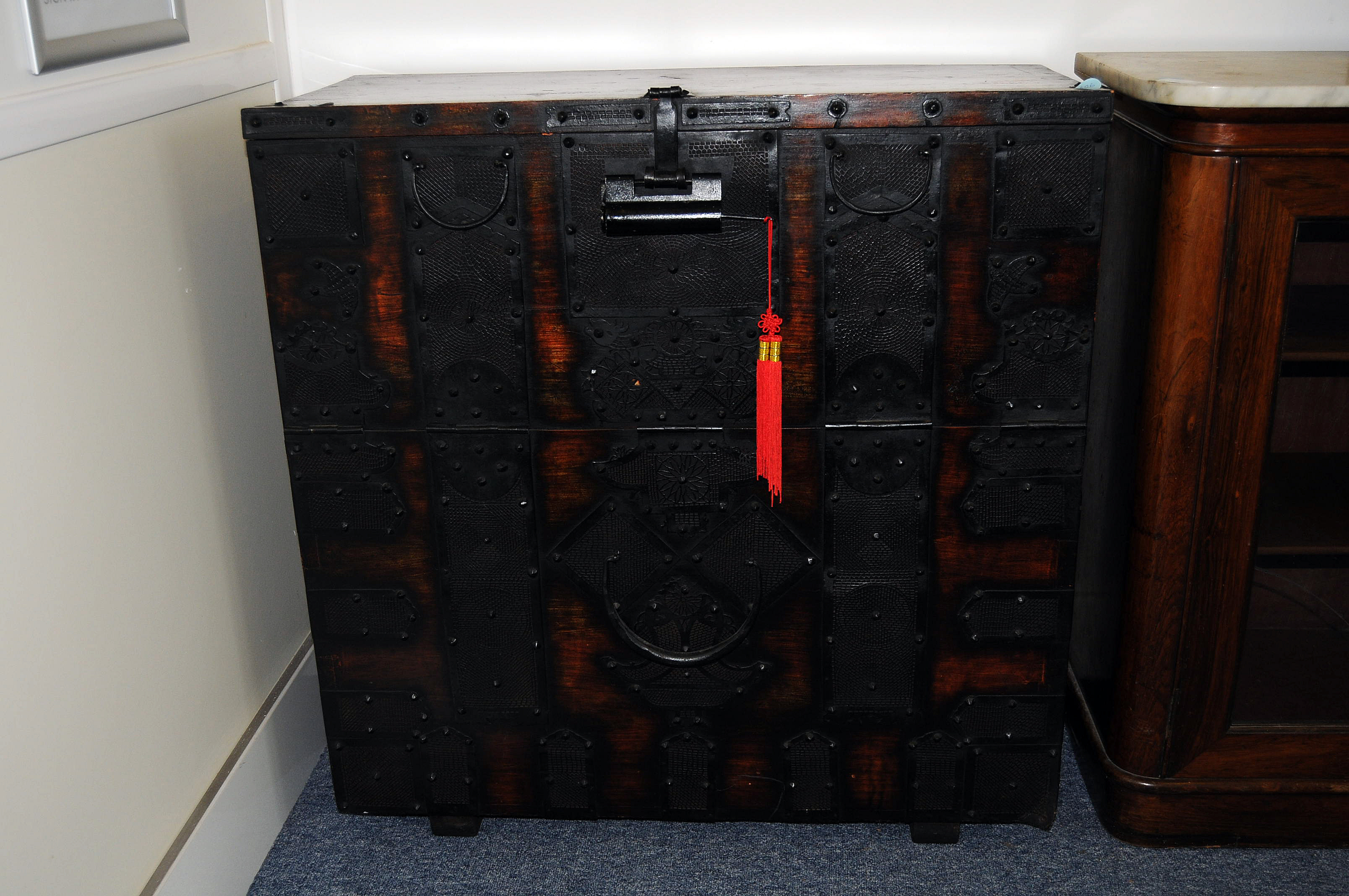 An early 20th century Korean hardwood chest with strapped corners, and decorated with pierced iron