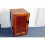 A 1950s cabinet, in mixed wood, with door opening to reveal drawer and shelves, stampled 1951 to