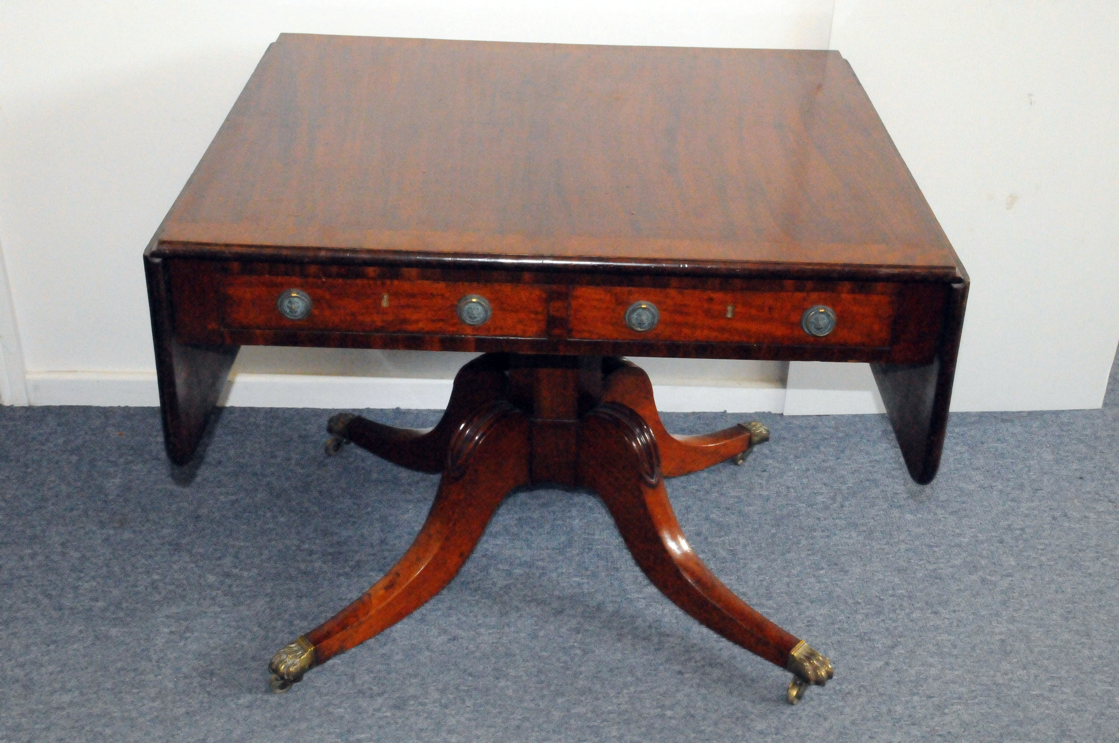 An Edwardian period mahogany sofa table, having drop leaf sides, two drawers to frieze and dummy