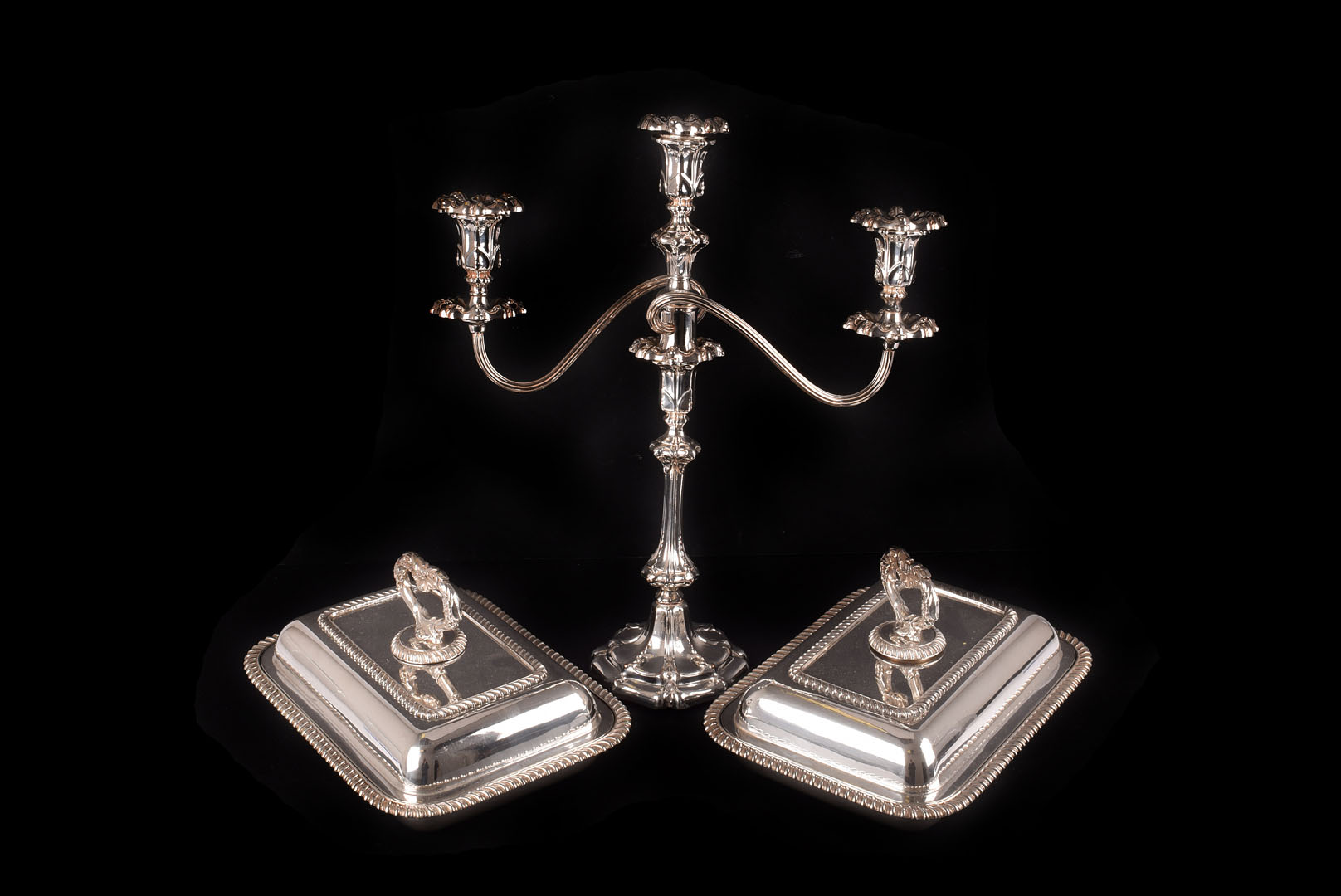 An Edwardian Sheffield plated candelabra, having two branches and central scone on stem support,