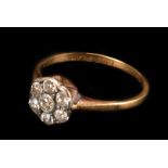 A diamond daisy cluster ring, platinum set, to a yellow gold shank stamped '18ct', finger size N/O