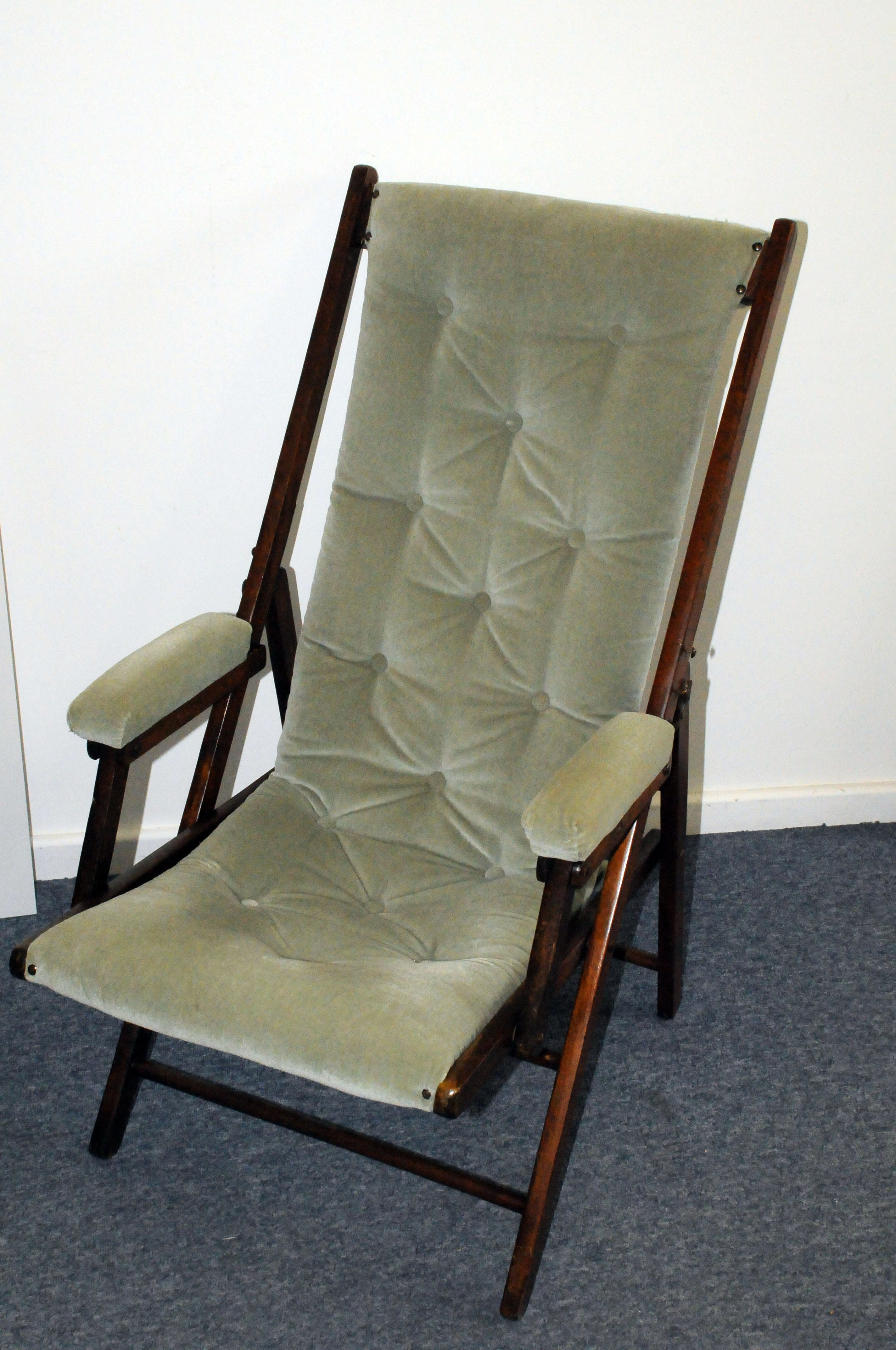 A vintage stained beech and upholstered folding campaign style chair, having light green modern