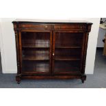 A late Victorian walnut and ebonised aesthetic glazed bookcase, having columns to each side, with