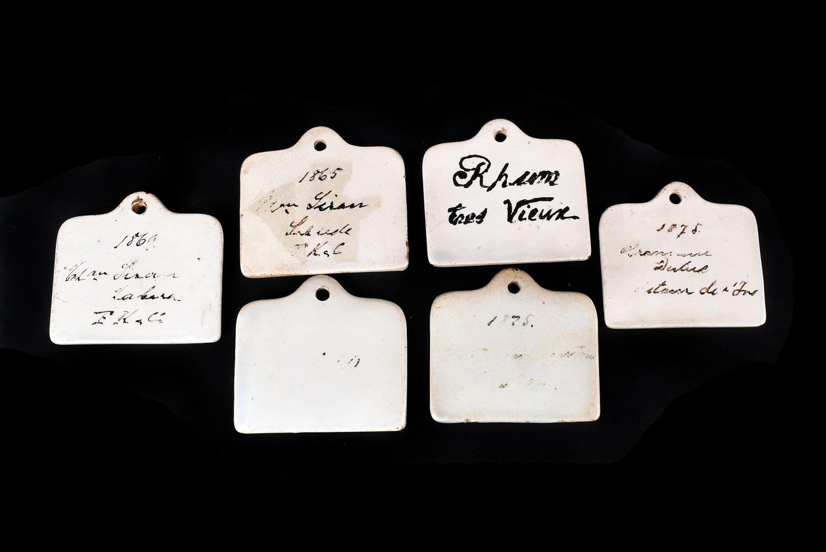 A collection of 19th century French ceramic wine labels, each hand painted with the description of