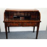 A 19th century walnut desk, having tambour roll with fitted interior, over two frieze drawers on