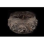 An Edwardian period Indian white metal bowl, having ornate raised and incised designs of animals and