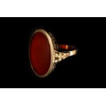 A 14ct gold and carnelian signet ring, the oval matrix uncut, to a open scrollwork gallery mount,