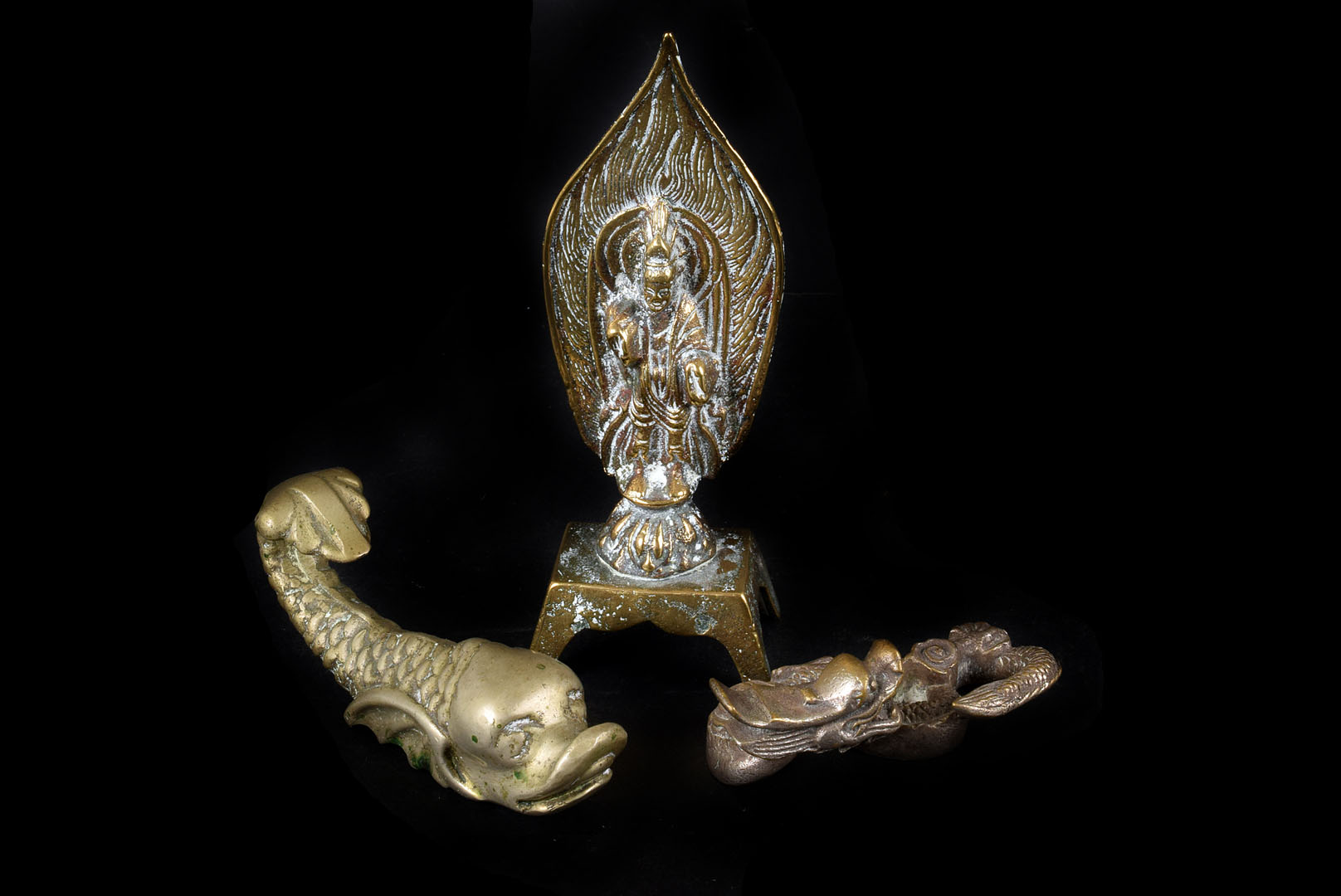 A Chinese brass deity of a figure stood on a plinth surrounded by flames, together with a white