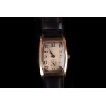 An Art Deco 9ct gold mid-size wristwatch, the barrel shaped case with silvered dial, the 15 jewel