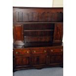 A George III period oak sideboard dresser, the base with three doors and drawers below shelved upper