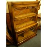 A three section oak stacking bookcase by Warwick, the fold down doors with leaded lights, 124cm