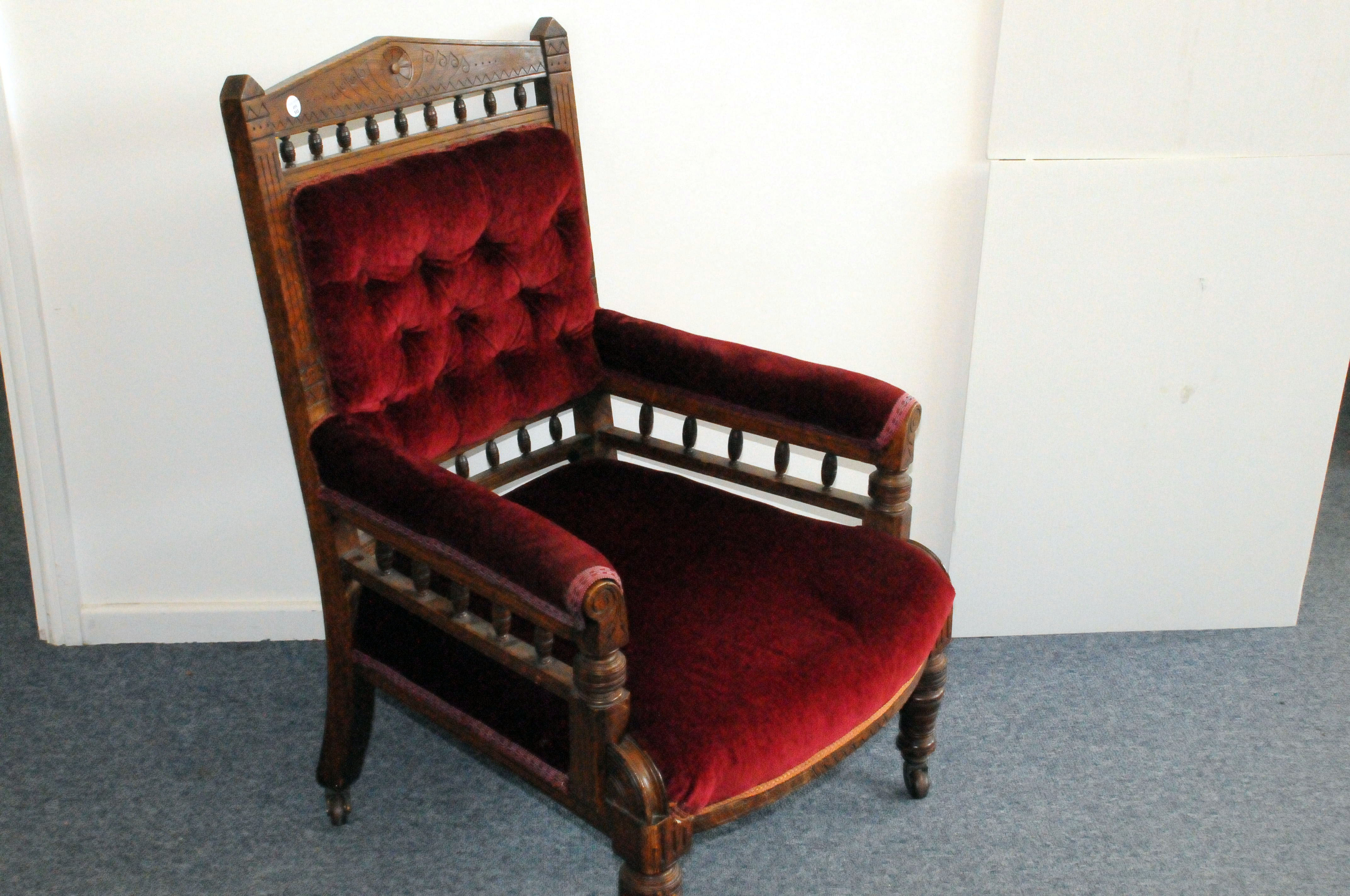 A Victorian stained beech and upholstered armchair, with carved design to top rail, having red