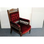 A Victorian stained beech and upholstered armchair, with carved design to top rail, having red