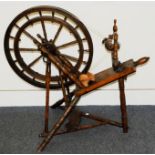 An antique hardwood spinning wheel, with cast iron fittings, overall in fair condition but some