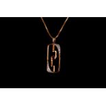 A modern yellow metal and gem set pendant on chain, the pierced oblong mount set with a central