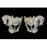 A pair of Chinese hardstone horse figures, the horses dressed with saddles and decorative dress,
