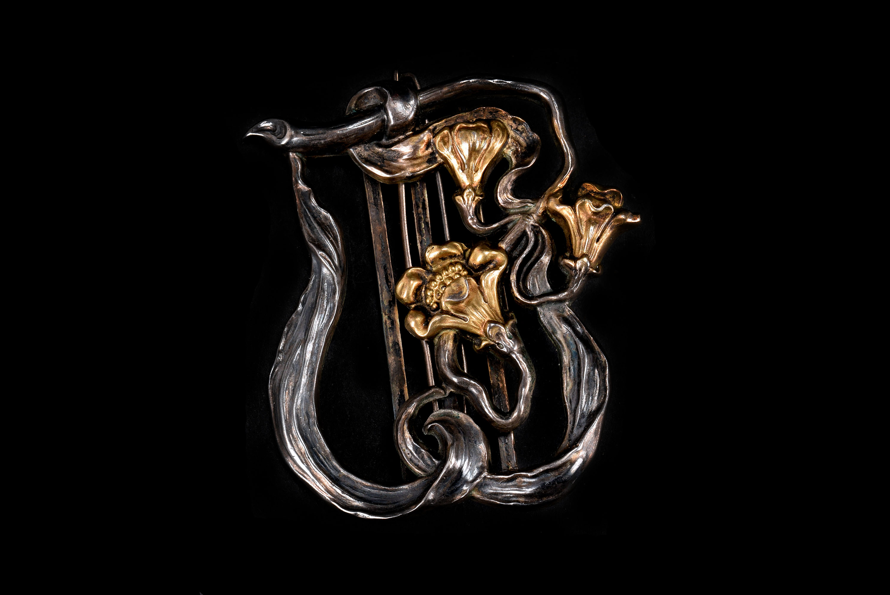 An Art Nouveau style French silver belt buckle, the organic sinuous curled stalks and leaves with