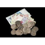 A collection of British coins and banks notes, including several one pound and ten shilling notes, a