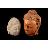 A large wooden carved Buddha's head, together with another example in stone, on wooden base (3)