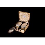 A George V vanity case, comprising two silver backed brushes, a comb with silver top, an oval mirror